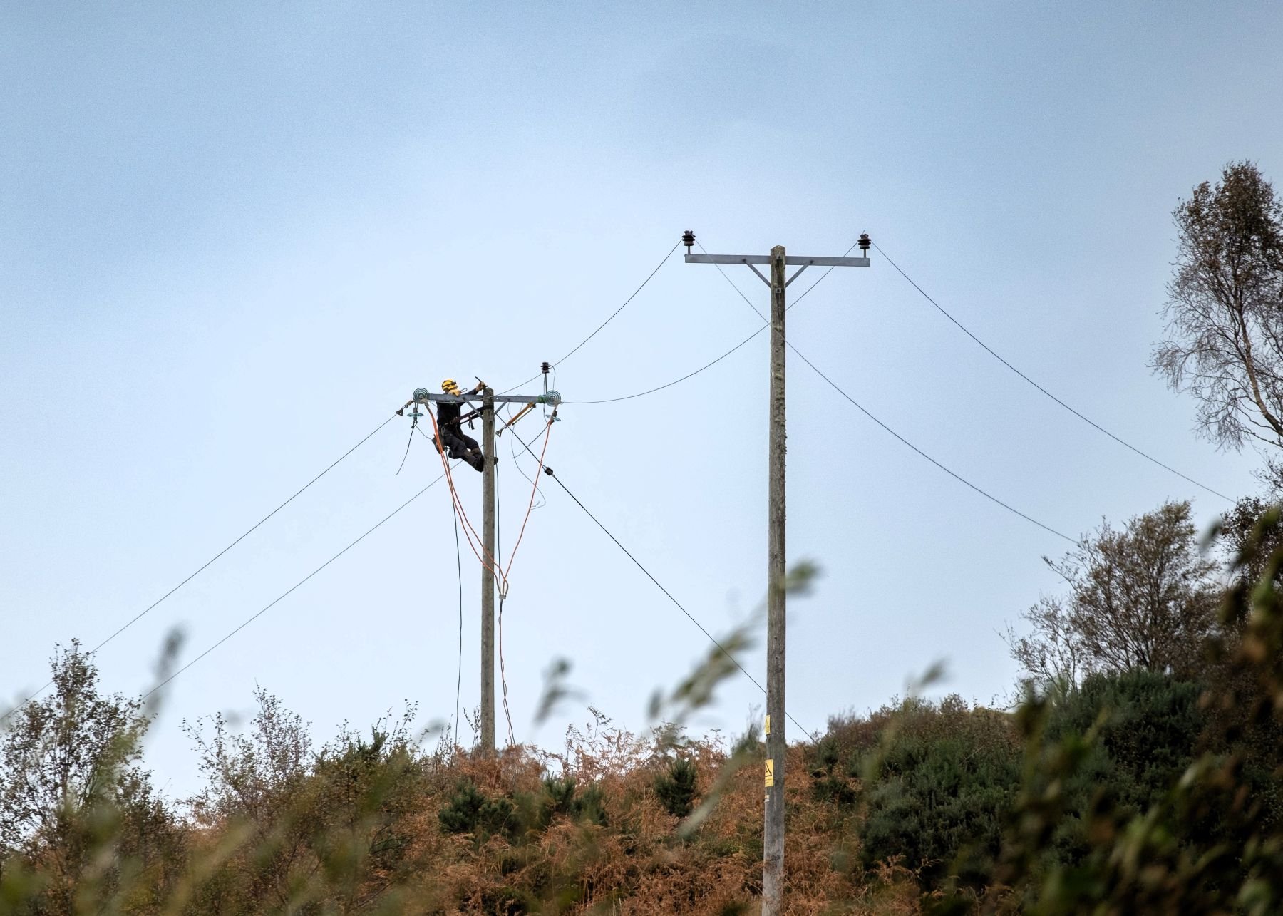 An SSEN engineer carrying out network repairs up a pole after Storm Amy