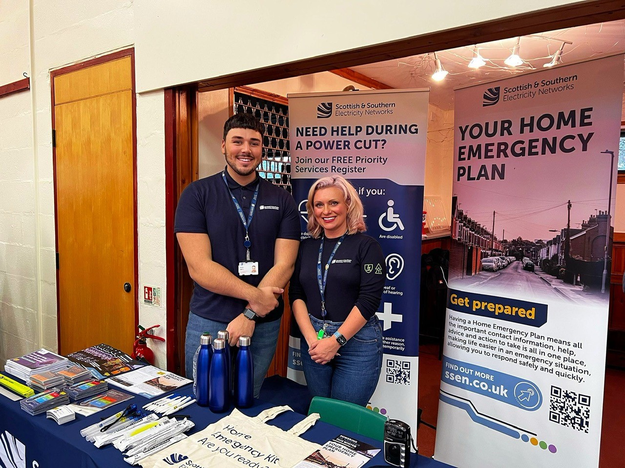Bradley and Samantha from SSEN standing at the SSEN resilience stand at Glenisla Hall