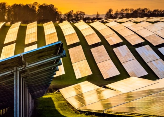 A photo of a solar farm at sunset