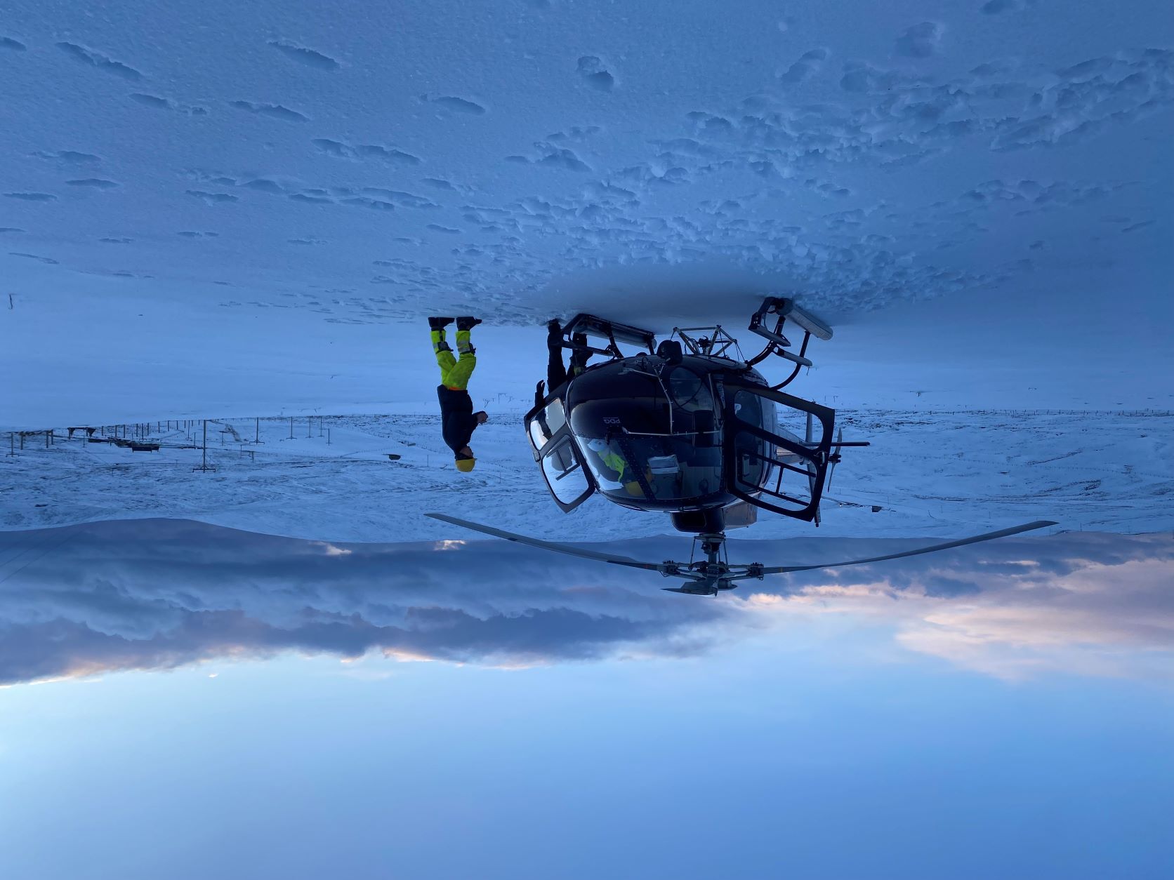 A helicopter in a snow-covered Shetland, heading out to patrol power lines