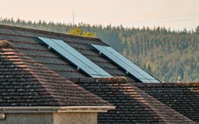 The roof of a small home with installed solar panels