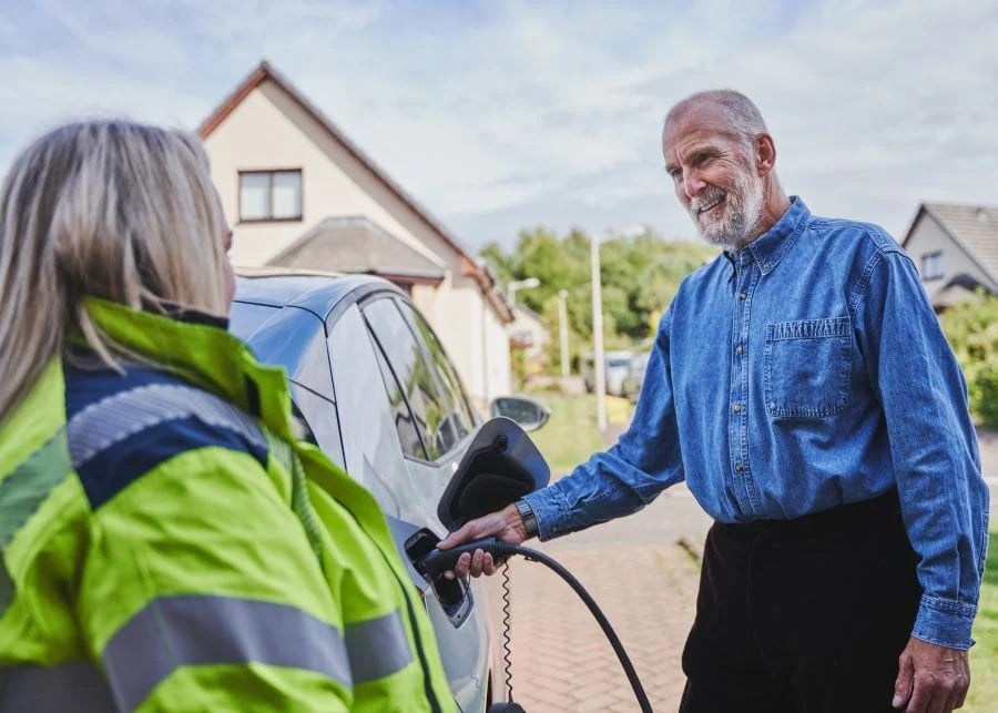 An SSEN engineer with a customer and their newly-installed EV charger An SSEN engineer with a customer and their newly-installed EV charger
