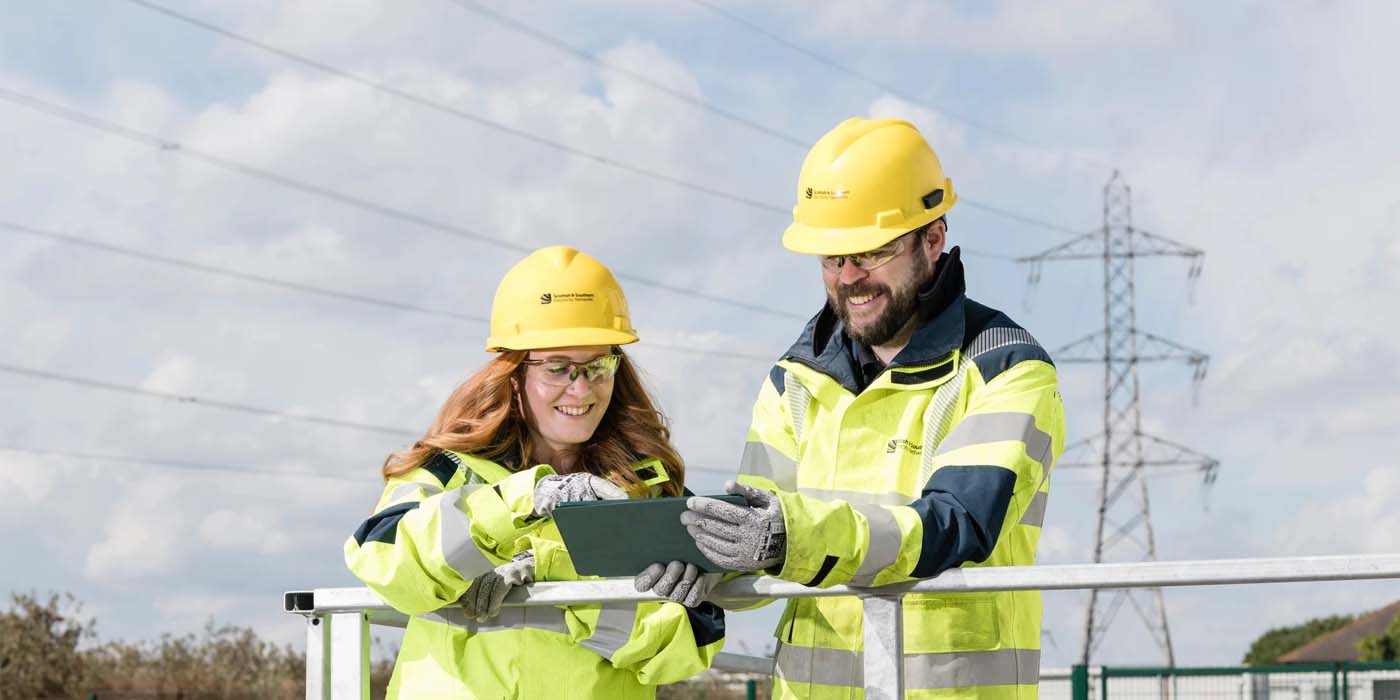 Male and female engineers in high vis outdoors
