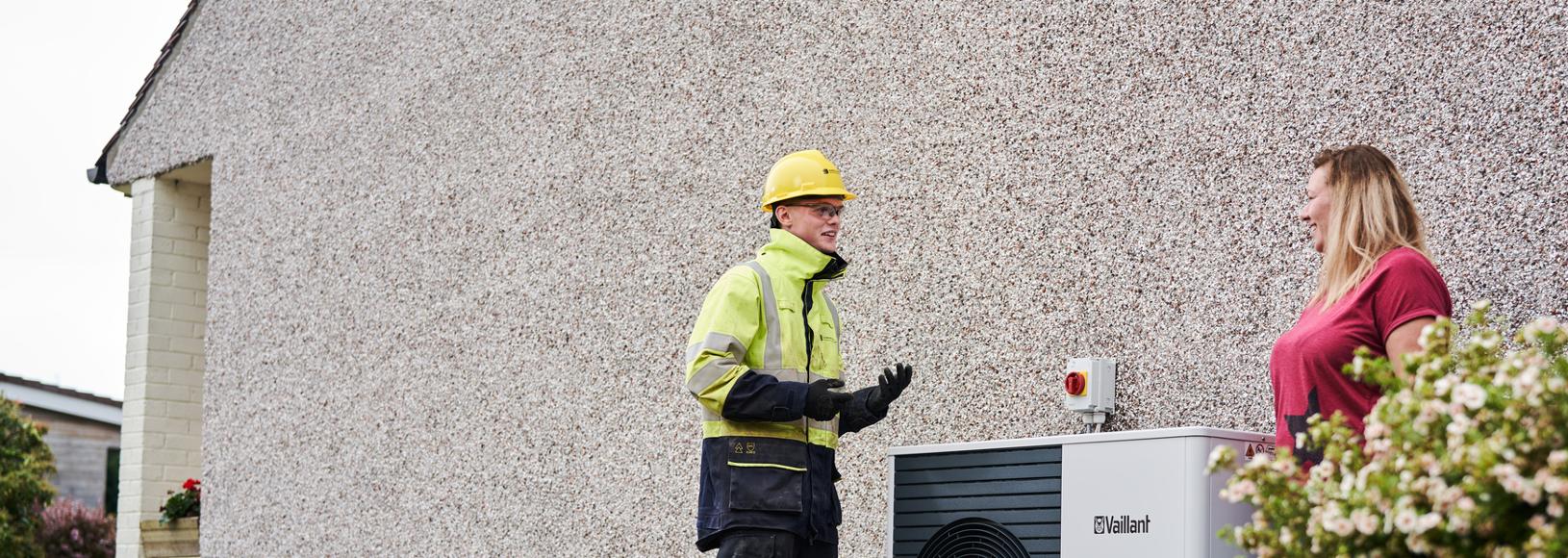 An SSEN engineer with a customer standing by a newly-installed heat pump