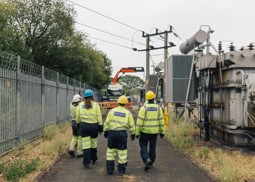 Project workers walking away from the camera through the North Baddesley site during construction work
