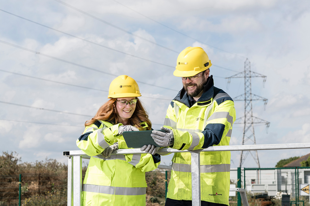 Male and female engineers outdoors in high vis