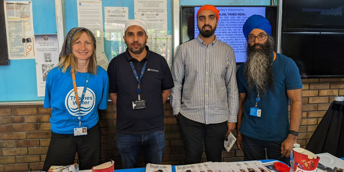 Woman and three men at table with leaflets