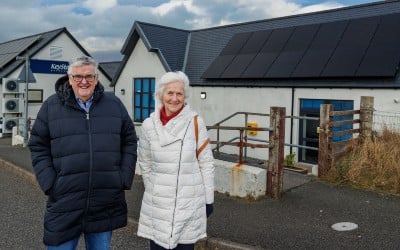 Norman MacKenzie (Point and Sandwick Trust) and Catriona Dunn (Urras Stòras An Rubha), at Aros an Rubha, with the installed Solar Panels (credit SandiePhotos)