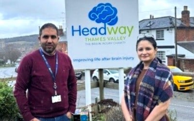 man and woman standing in front of Headway sign