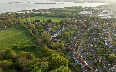 An aerial view of part of SSEN Distribution's central southern England licence area, showing houses, fields, industrial units and open water