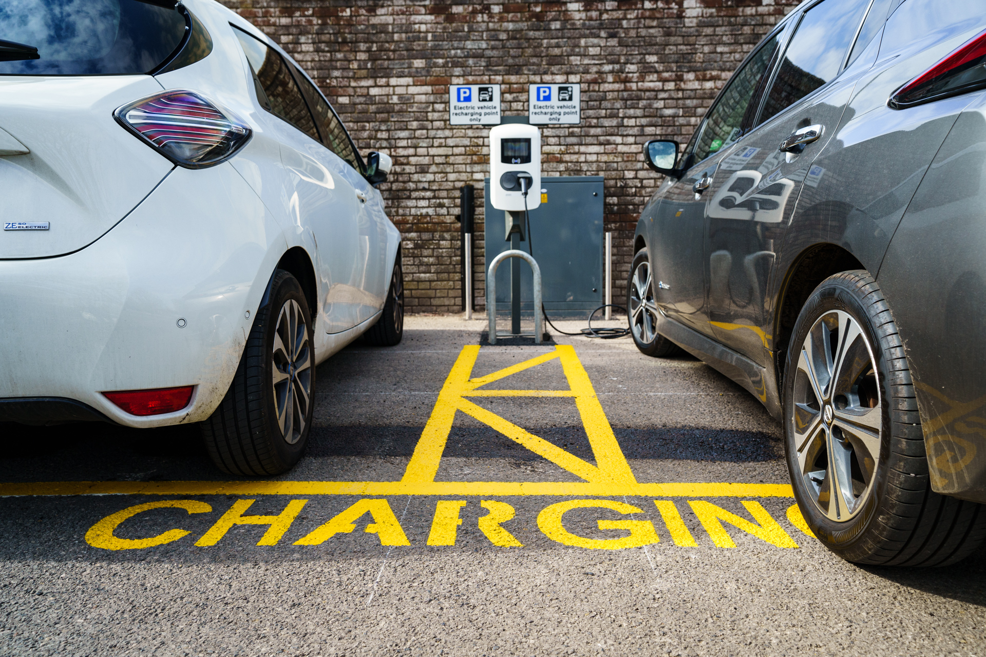 Cars in electric vehicle charging bay