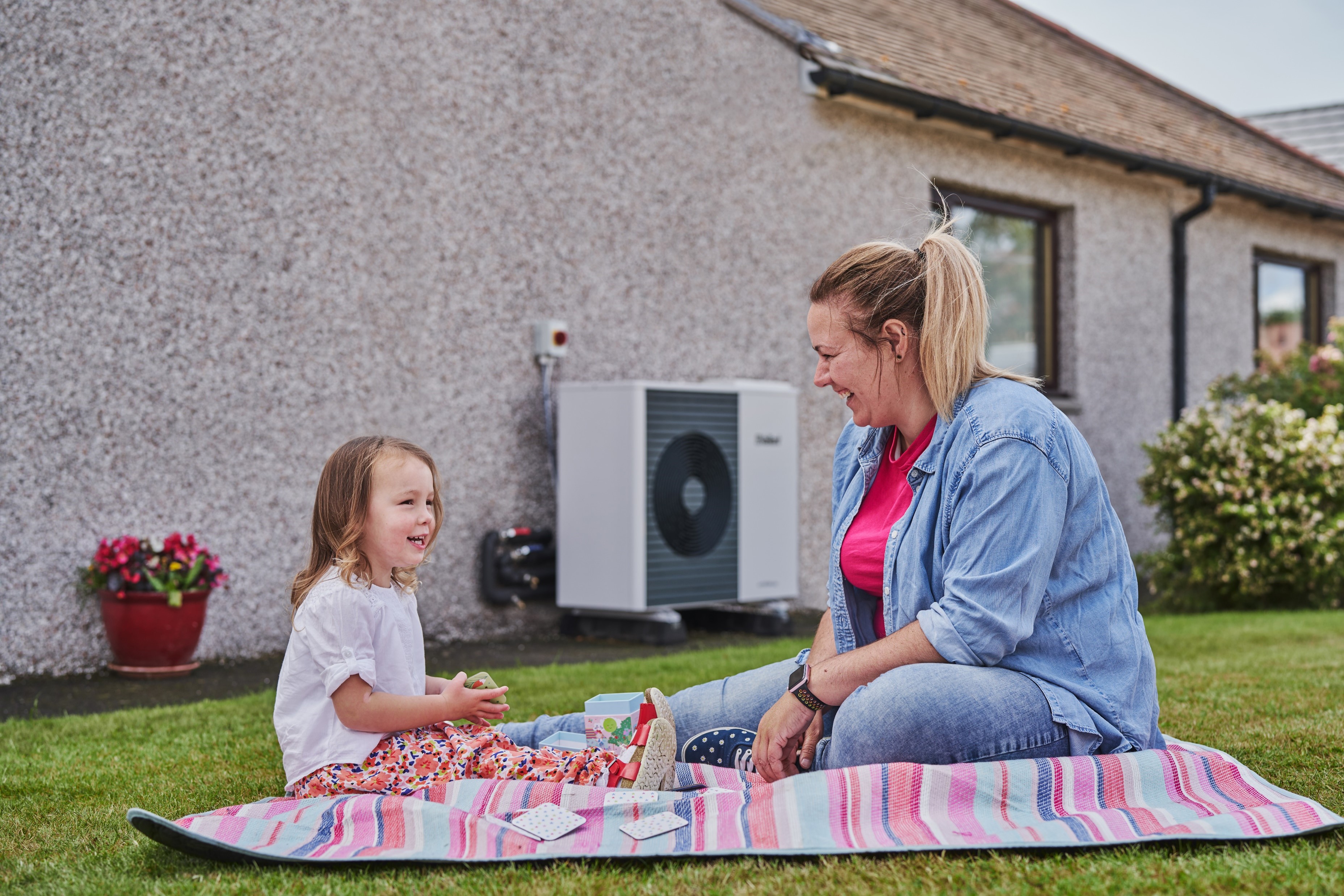 Family in their garden with a heat pump