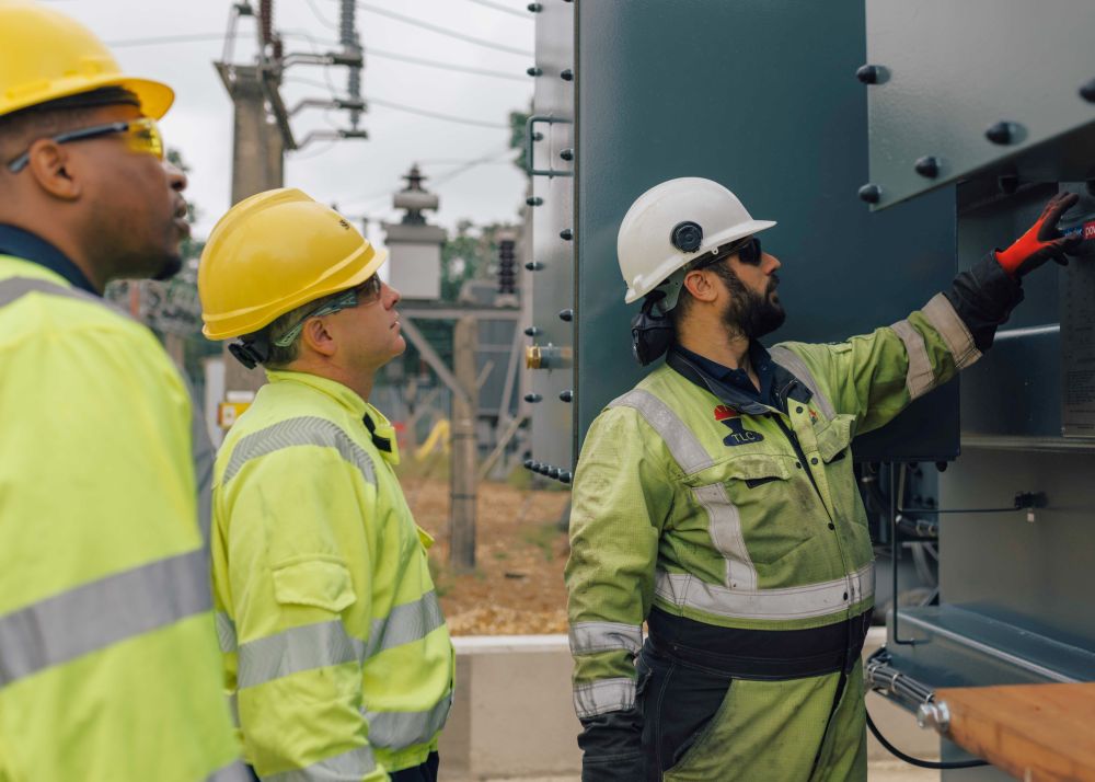 Engineers in high vis working at outdoor transformer