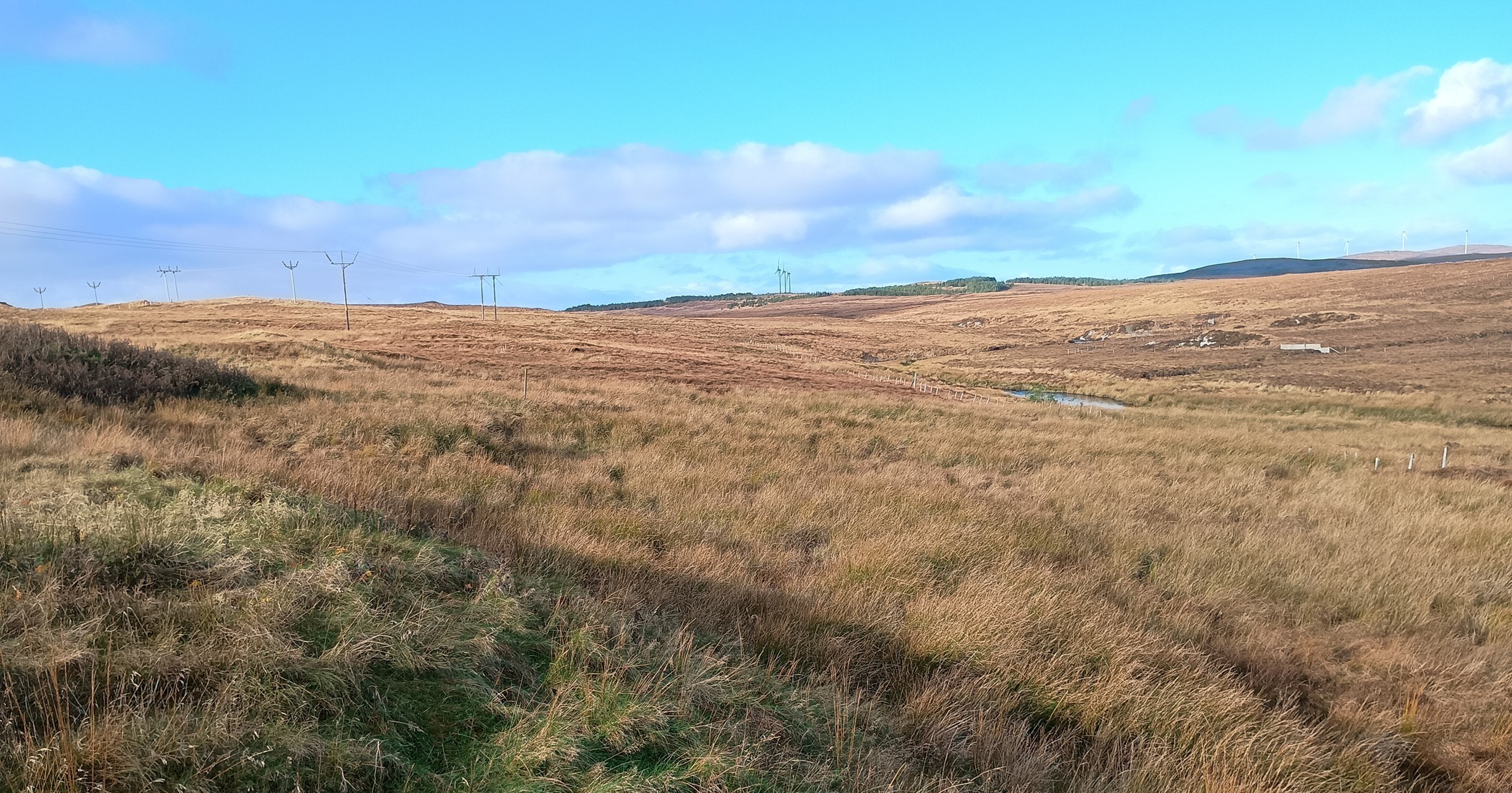 Brown hills in the countryside with bright blue sky shining on top.
