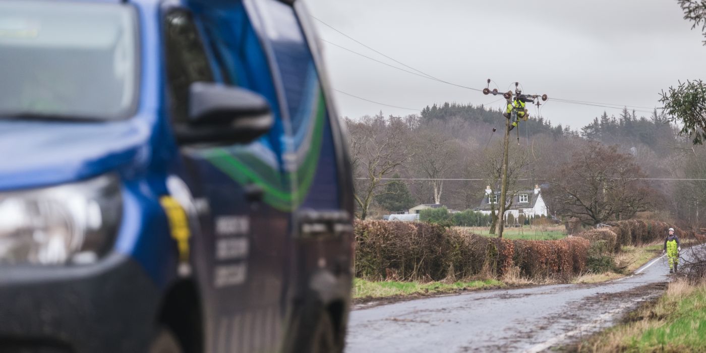 An SSEN vehicle driving past storm damage