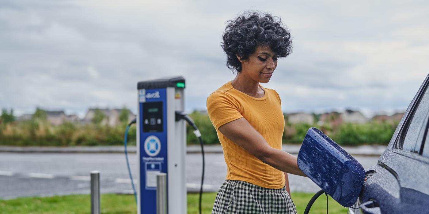 A customer charging their car using an EV fast-charger