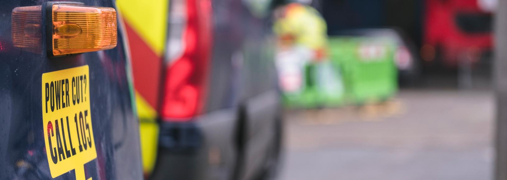 An out-of-focus shot with vehicles in the foreground and roadworks in the background