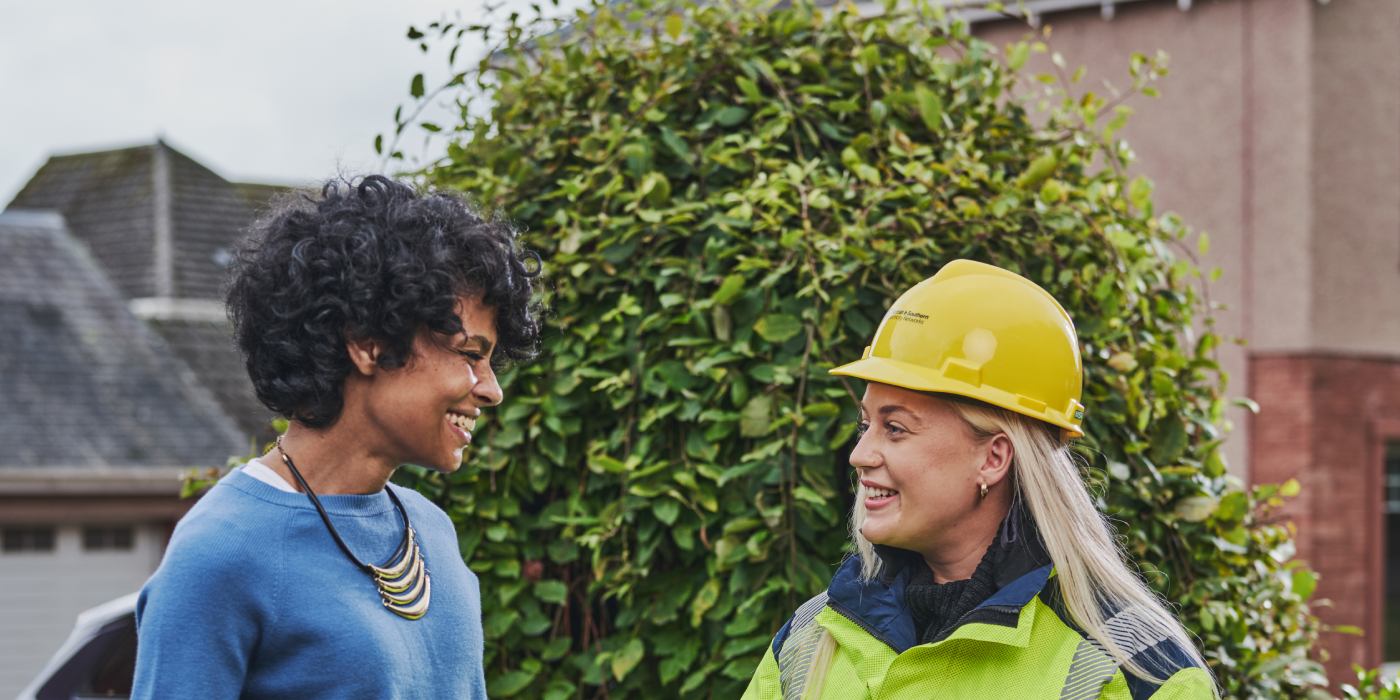 Female engineer in high vis with customer