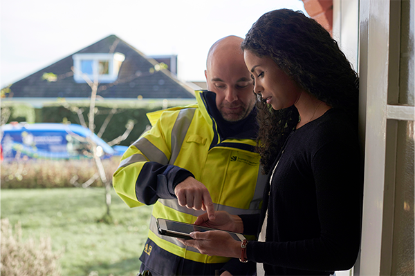 Image of SSEN engineer showing a customer how to log a report on our Power Track map on her tablet 