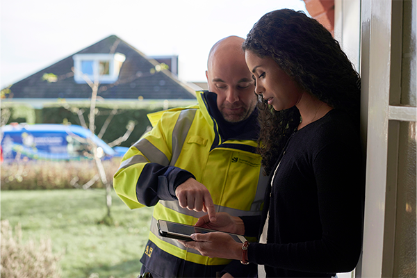 Engineer looking at mobile with customer 