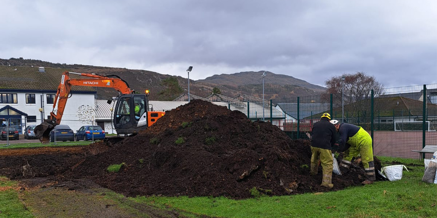 Digger clearing playground
